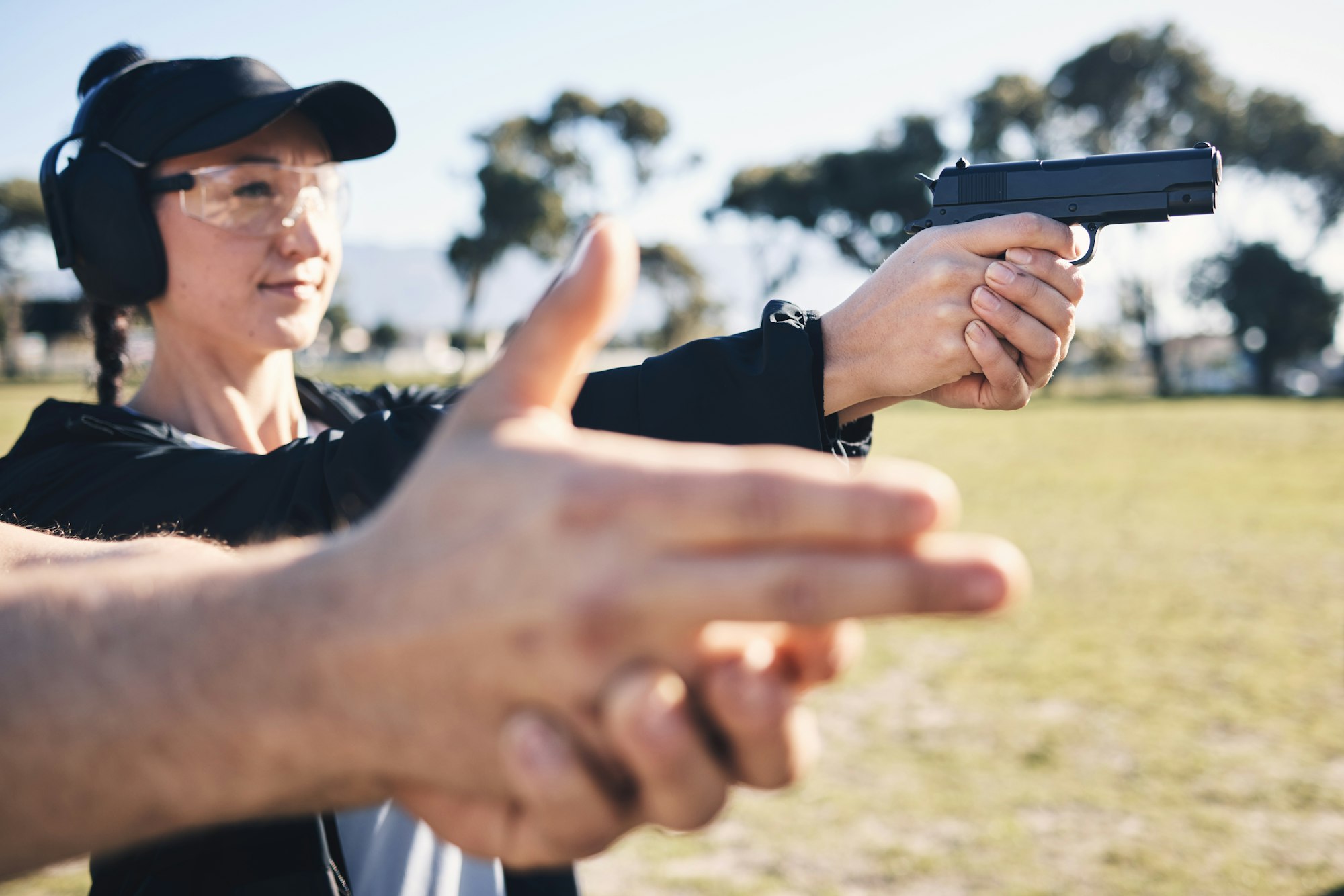 Man, woman and gun training with aim, outdoor target or hand position at police, army or security a